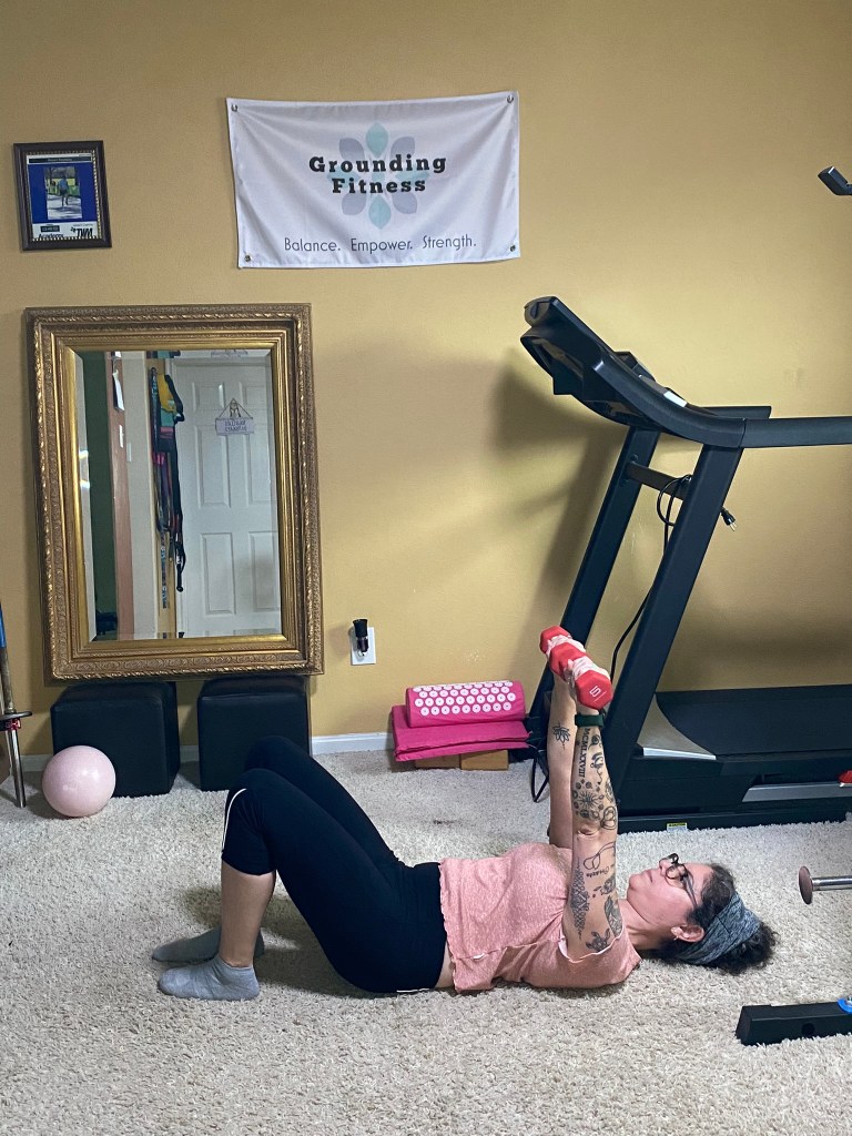 carola performing floor the chest press with weights