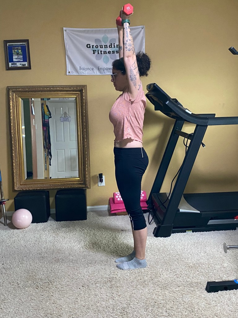 Carola performing the overhead press with weights